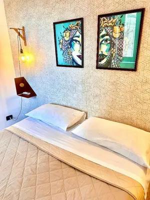 a bedroom with a bed with three pictures on the wall at Via del Bosco Home in Palermo