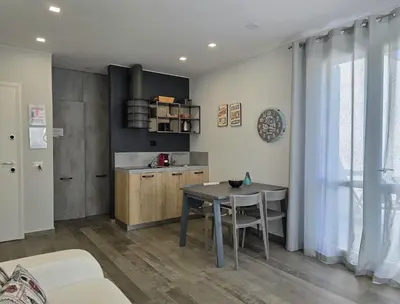 a living room with a table and a kitchen at Casa Bambù in Macari