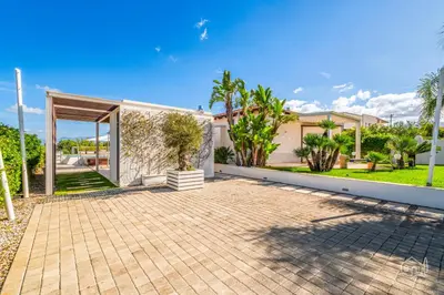a house with a courtyard with palm trees at Villa Ametista in Alcamo