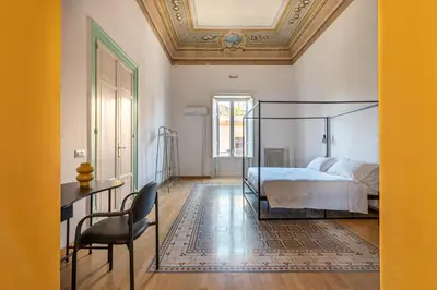 a bedroom with a bed and a table and a chair at Carlo Apartment with Terrace by Wonderful Italy in Palermo