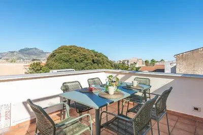 a patio with tables and chairs on a balcony at Carlo Apartment with Terrace by Wonderful Italy in Palermo