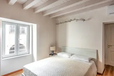 a bedroom with a bed with a black headboard and two lamps at Vittorio Emanuele Suites&Apartments in Palermo