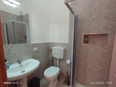 a bathroom with a white toilet and a sink at Casa Claudia in Palermo