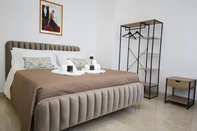 a bedroom with a large bed with a shelf at Tolo Tolo Apartaments in Palermo