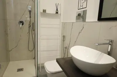 a bathroom with a sink and a toilet and a shower at Tolo Tolo Apartaments in Palermo