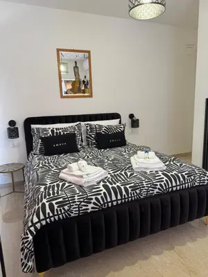 a black and white bed with two towels on it at Tolo Tolo Apartaments in Palermo