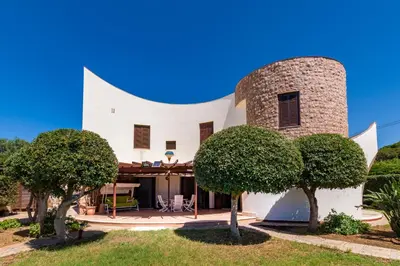 a white house with trees and a mountain in the background at LeSicilien - Tilde Sunset Bay Villa in Carini