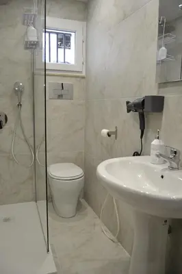 a bathroom with a shower and a toilet and a sink at VitaNova Apartment in Palermo