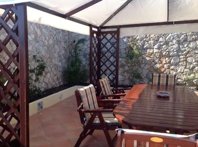a wooden table and chairs on a patio at Villa Dorotea in Castellammare del Golfo
