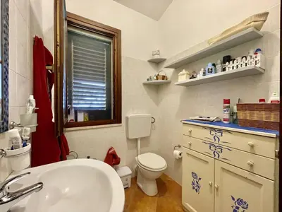 a bathroom with a sink and a toilet and a window at Villa Dorotea in Castellammare del Golfo