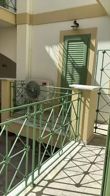 a balcony of a building with a green railing at Le Case di Zefiro in Santa Flavia