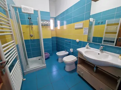 a blue and yellow bathroom with a toilet and sink at Case d'estate Mondello in Palermo