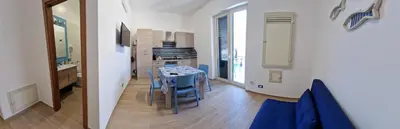 a kitchen and dining room with a blue table and chairs at Casa Fortuna Mondello in Palermo