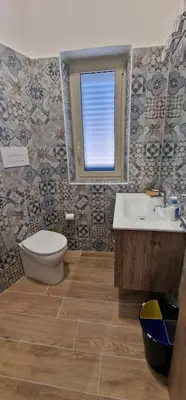 a bathroom with a toilet and a sink and a window at Casa Elisa in Palermo