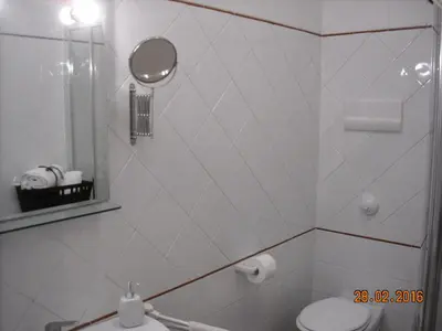 a white bathroom with a toilet and a mirror at Marku's House in Palermo