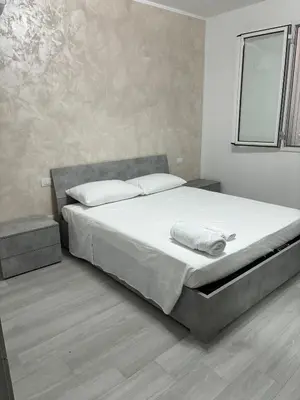 a bedroom with a large bed with white sheets at BALISTRERI HOUSe in Trabia