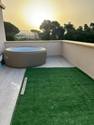 a balcony with a green rug and a fire pit at BALISTRERI HOUSe in Trabia
