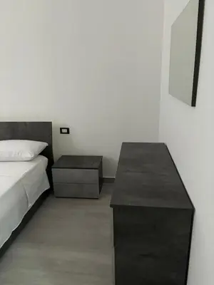 a bedroom with a bed and a nightstand and a table at BALISTRERI HOUSe in Trabia