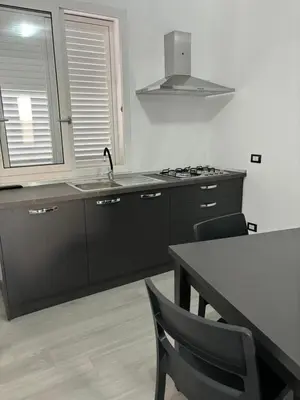 a kitchen with a sink and a table with chairs at BALISTRERI HOUSe in Trabia