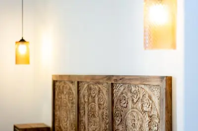 a wooden headboard in a room with a white wall at Rosalia e le altre in Palermo