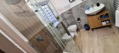 a bathroom with a shower and a toilet and a sink at Onyx Home in Palermo