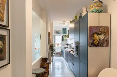 a kitchen with blue cabinets and a hallway with a table at Terrace in the Sky overlooking Historic Center in Palermo
