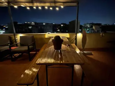 a wooden table on a balcony with a plant on it at Terrace in the Sky overlooking Historic Center in Palermo