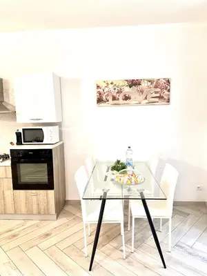 a kitchen with a glass table and white chairs at Bandiera's House in Palermo