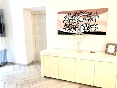 a white cabinet in a room with a painting on the wall at Bandiera's House in Palermo