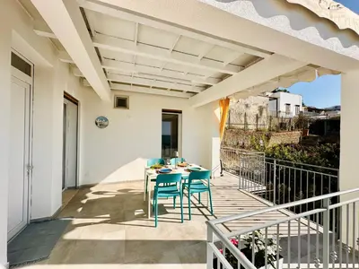 a patio with a table and chairs on a balcony at Zàgave Apartment a 200 mt dal mare in Alcamo