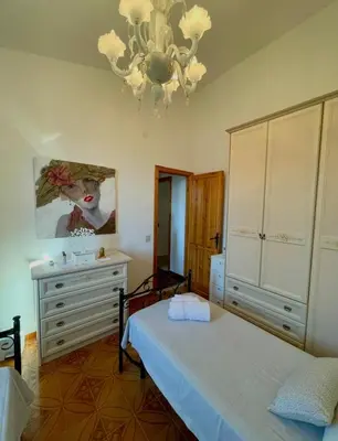 a bedroom with two beds and a chandelier at Villa Seaside in Cinisi