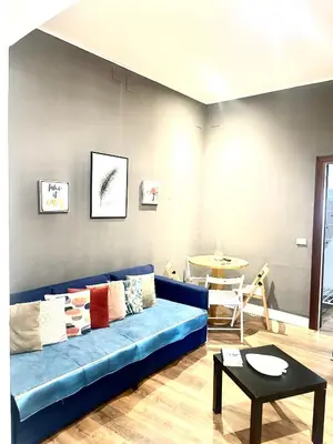 a living room with a blue couch and a table at Porta di Castro's Home in Palermo
