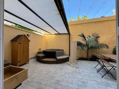 a patio with a couch and a table and a fence at Oasi urbana Palermo in Palermo