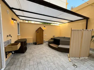 a covered patio with a couch and a sink at Oasi urbana Palermo in Palermo