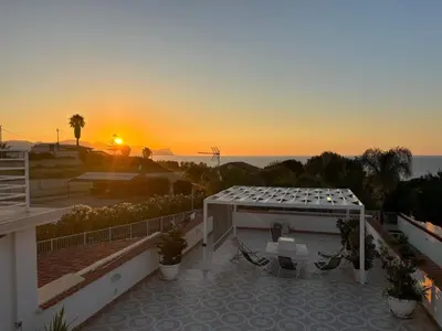 a sunset over a patio with a table and chairs at Holiday Home Casa Gaetano by Interhome in Balestrate