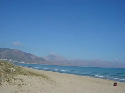 a beach with the ocean and mountains in the background at Holiday Home Villa Aliotis 200m vom Meer entfernt by Interhome in Alcamo Marina