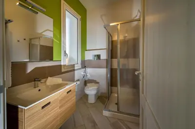 a bathroom with a toilet and a sink and a shower at APT RINO Sea View basement in Villa Rosaria in Scopello