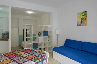 a bedroom with a blue couch and a bed at Visitsicilia Saramia in Balestrate