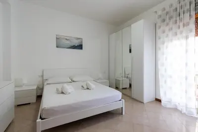 a white bedroom with a bed and a mirror at Visitsicilia Saramia in Balestrate