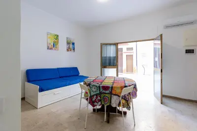 a living room with a blue couch and a table at Visitsicilia Saramia in Balestrate