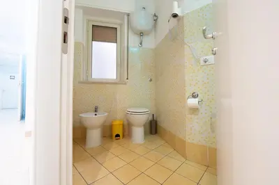 a bathroom with a toilet and a window at Palermo Central BB in Palermo
