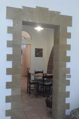 a dining room with a table and a stone wall at Apartment Wohnung mit Wasserblick by Interhome in Castellammare del Golfo