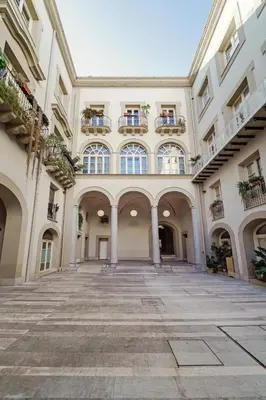 an empty courtyard of a building with a balcony at Hybrid Icon Rooms Gallery City Center in Palermo
