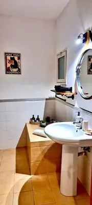 a bathroom with a white sink and a mirror at Loft Materassai in Palermo