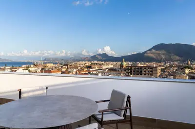 a table and a chair on a balcony with a view at Skyline Boutique Hotel in Palermo