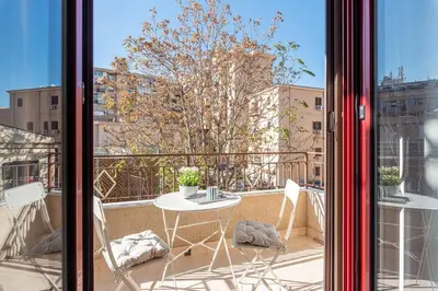 a balcony with a table and chairs and a window at Ludohome in Palermo
