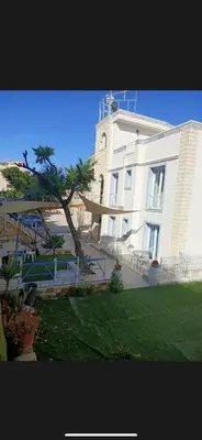 a large white building with a tree in front of it at Casita Blanca in Santa Flavia