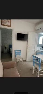 a living room with a couch and a table and chairs at Casita Blanca in Santa Flavia