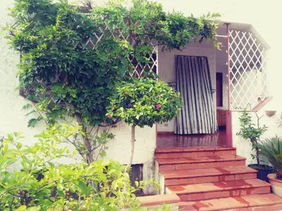 a house with a staircase leading to a door at O Firrìu in Carini