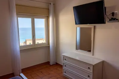 a room with a television and a dresser with a window at casavacanzabordonaro in Palermo